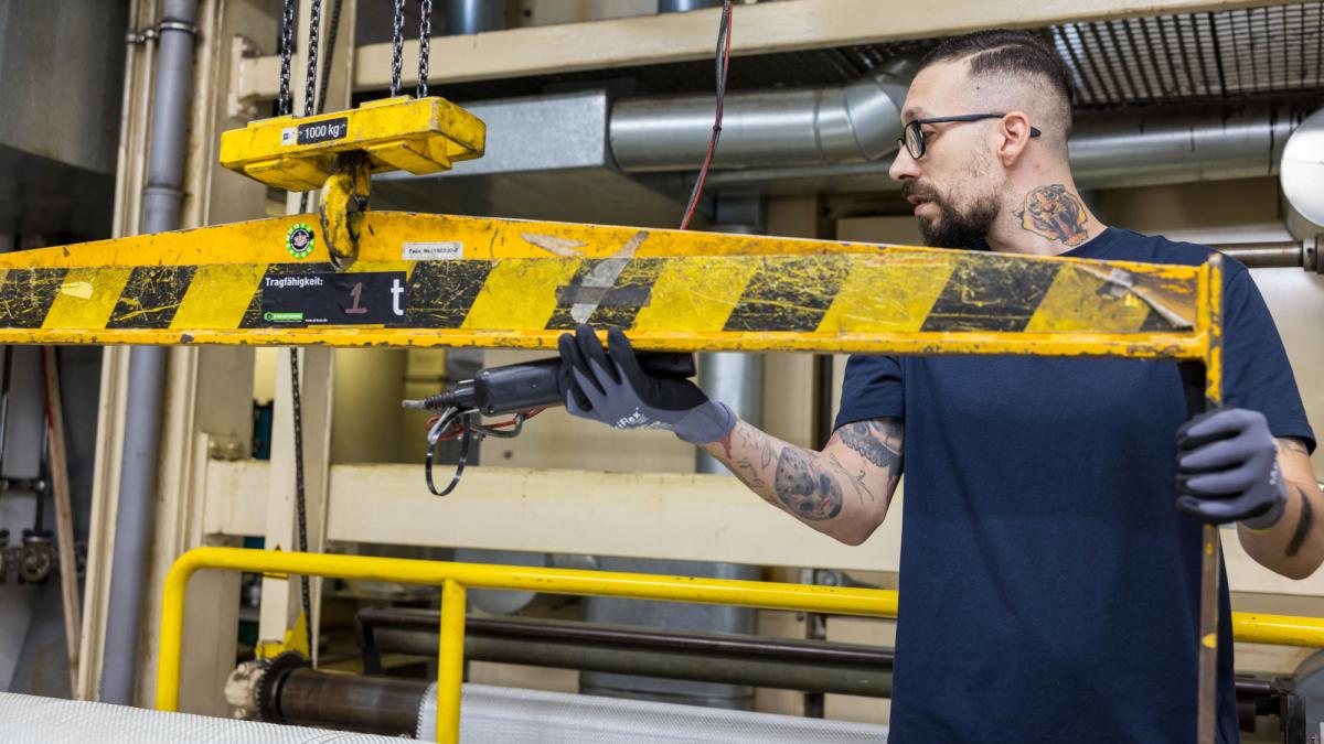 Man working on a machine looking at the side of the image