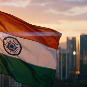The Indian flag flutters in the sunset, with a skyline visible in the background.