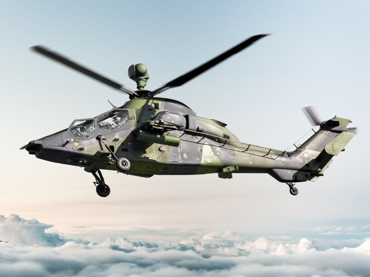 Se ve un helicóptero con los colores del ejército volando sobre una capa de nubes.
